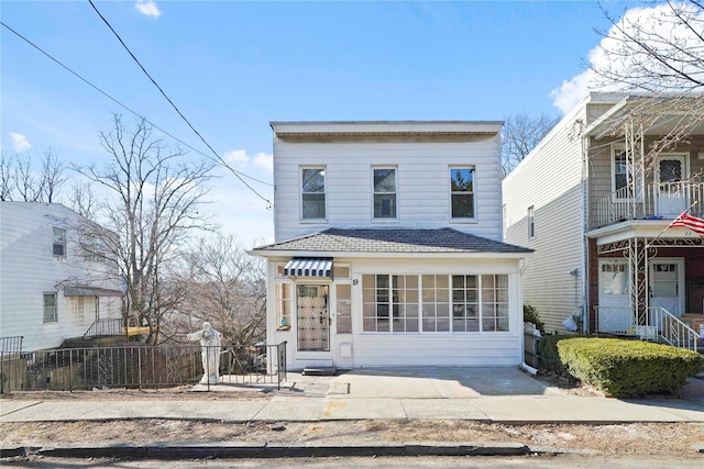 view of front of property with a shingled roof and fence