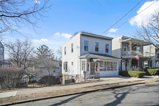 view of front of house featuring a fenced front yard and a balcony