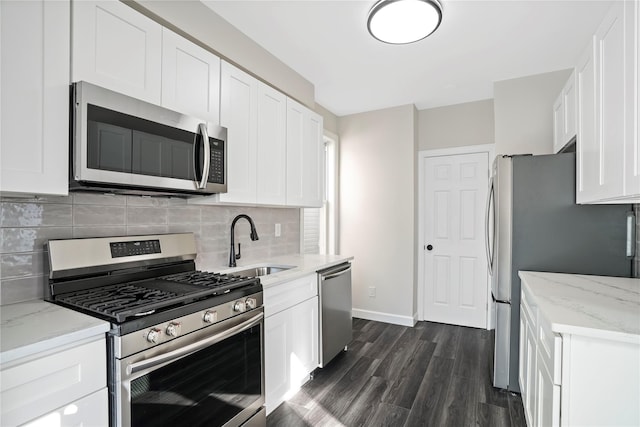 kitchen with a sink, dark wood-type flooring, appliances with stainless steel finishes, and white cabinets