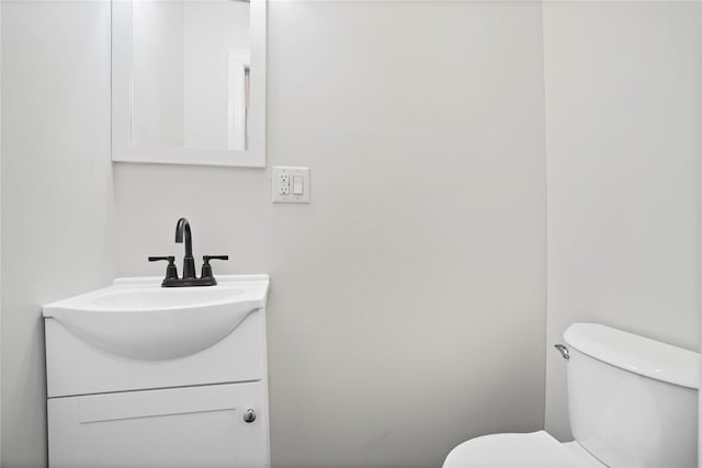 half bath featuring toilet and vanity