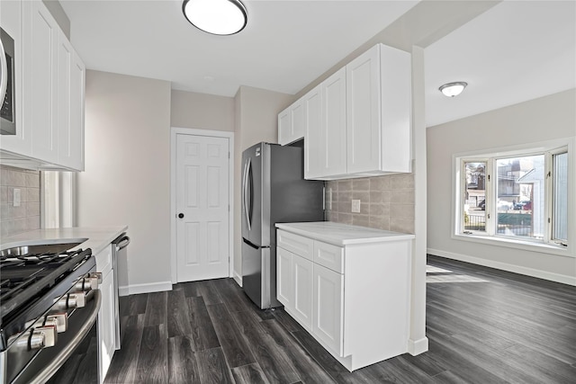 kitchen with dark wood-type flooring, appliances with stainless steel finishes, white cabinets, and light countertops