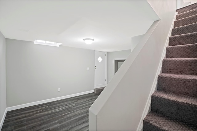 stairs featuring wood finished floors and baseboards