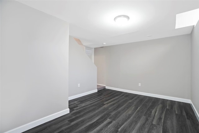 spare room with dark wood-type flooring and baseboards