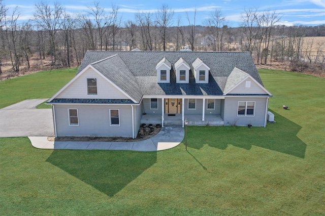 view of front facade featuring a porch, a shingled roof, and a front lawn