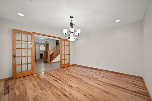 empty room with light wood-style flooring, recessed lighting, stairway, baseboards, and a chandelier