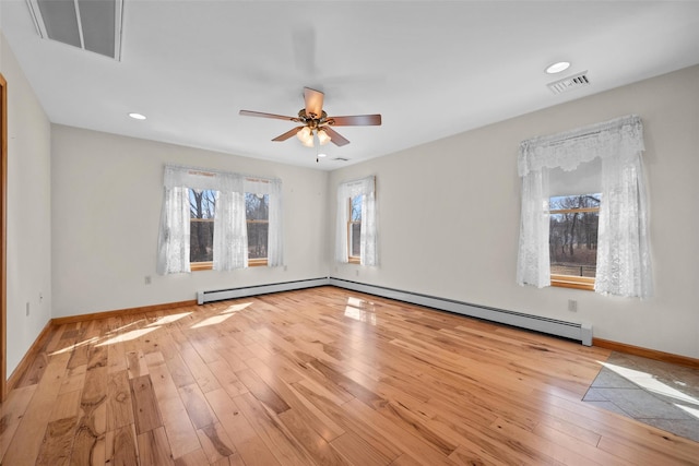 empty room featuring visible vents, wood-type flooring, baseboards, and ceiling fan