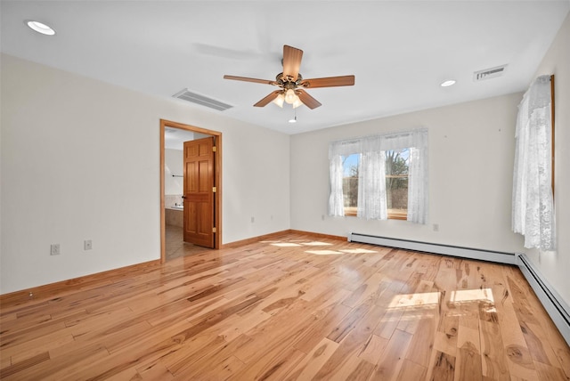 empty room with a baseboard heating unit, light wood-style floors, and visible vents