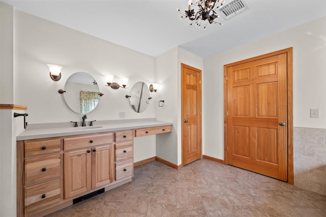 bathroom with a notable chandelier, visible vents, vanity, and baseboards