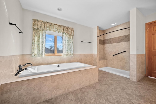 bathroom with tiled shower and a bath