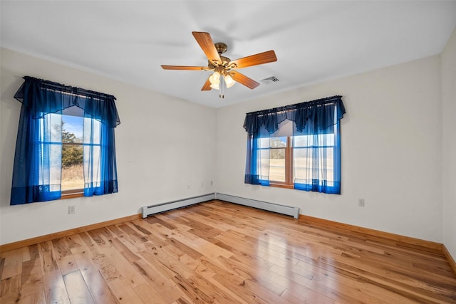 empty room with a healthy amount of sunlight, wood-type flooring, and ceiling fan