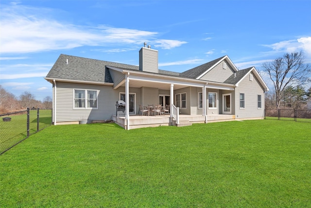 rear view of property featuring a shingled roof, a lawn, a fenced backyard, and a chimney