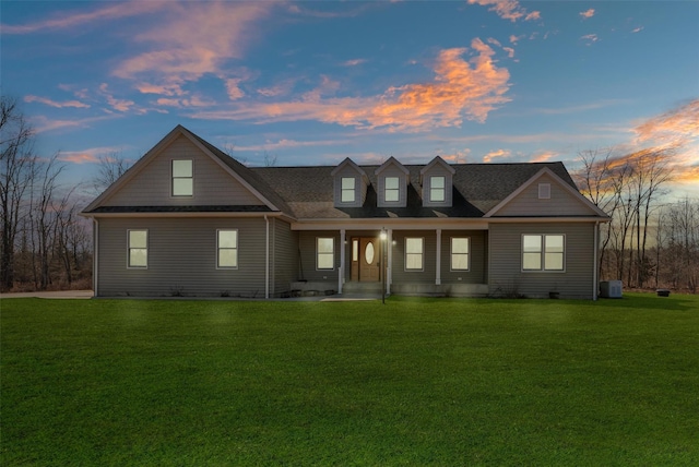 view of front of house featuring cooling unit and a yard