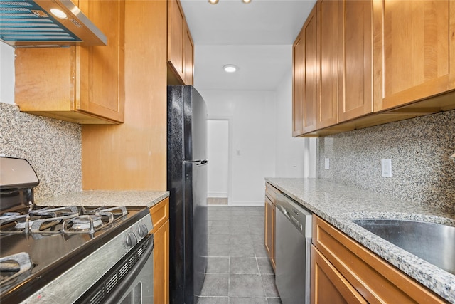 kitchen featuring tile patterned flooring, backsplash, baseboards, appliances with stainless steel finishes, and exhaust hood