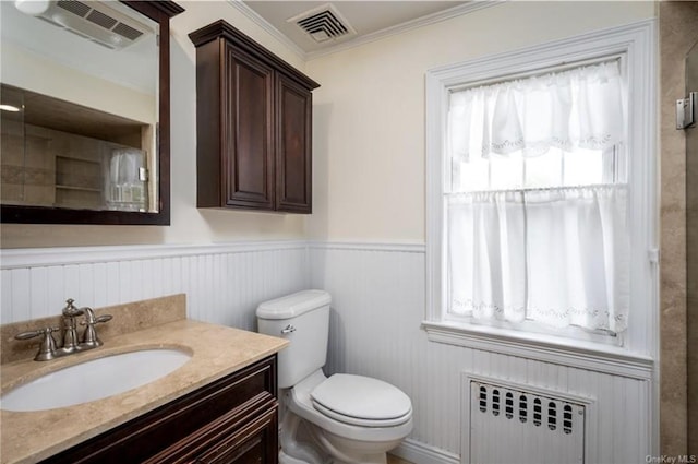 bathroom with visible vents, wainscoting, radiator, and toilet