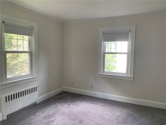 spare room featuring baseboards, carpet floors, radiator, and crown molding