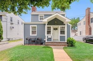 view of front of home featuring a chimney and a front lawn