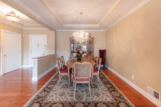 dining space with a chandelier, visible vents, baseboards, and wood finished floors