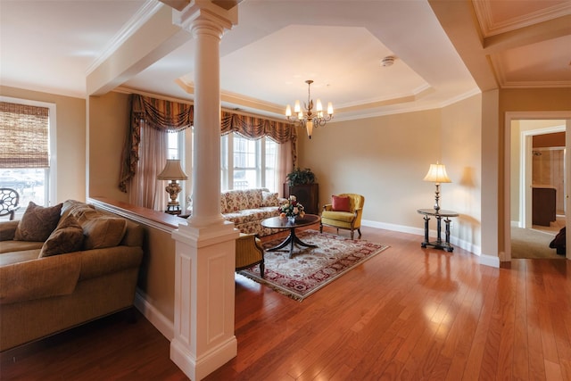 living area featuring baseboards, an inviting chandelier, decorative columns, hardwood / wood-style flooring, and crown molding