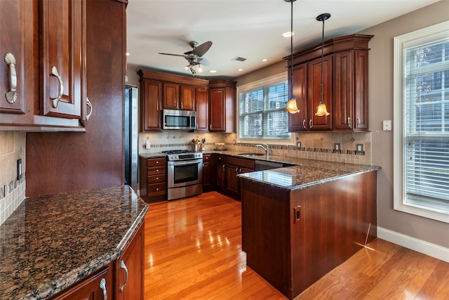 kitchen featuring a sink, light wood-style flooring, a ceiling fan, and stainless steel appliances