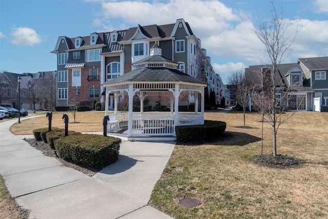 view of front of home with a gazebo, a front yard, and a residential view