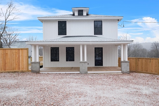 traditional style home featuring central air condition unit, covered porch, roof with shingles, and fence