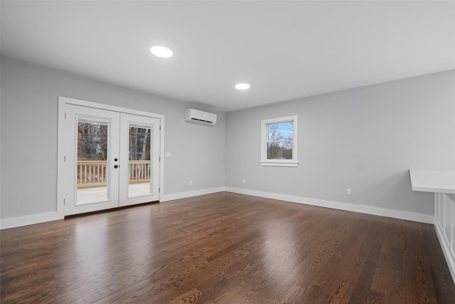 unfurnished room with dark wood-style floors, french doors, an AC wall unit, and baseboards