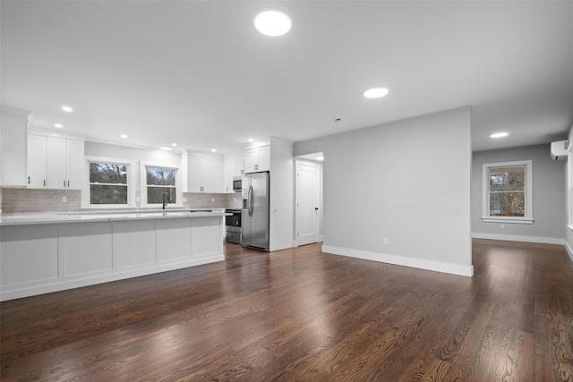 unfurnished living room with recessed lighting, dark wood-style floors, and baseboards