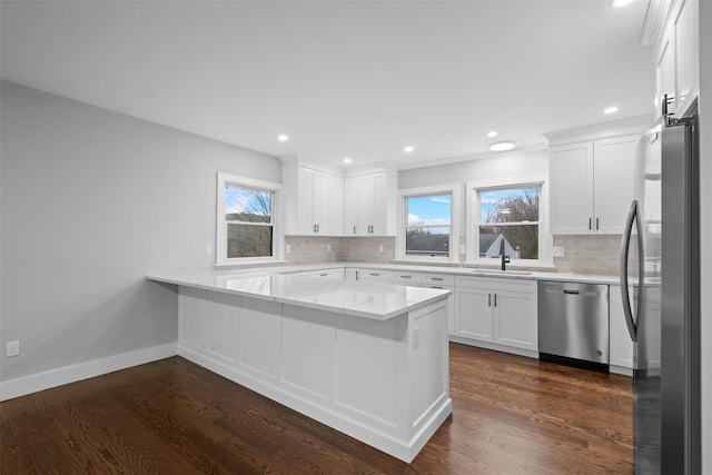 kitchen with white cabinets, appliances with stainless steel finishes, dark wood-type flooring, and a sink