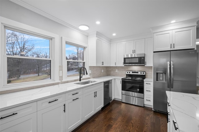 kitchen featuring backsplash, appliances with stainless steel finishes, white cabinets, and a sink