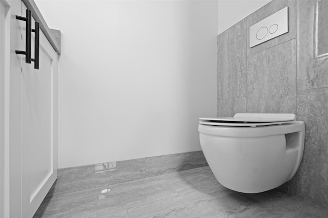 bathroom featuring toilet and tile walls