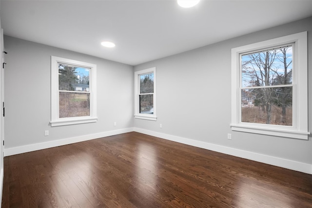 empty room with baseboards and dark wood-style flooring