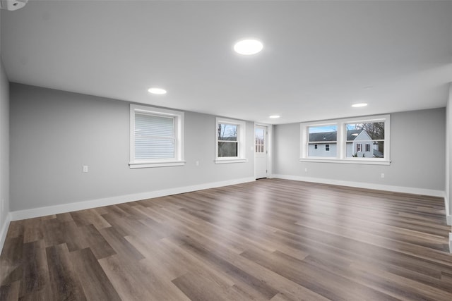 unfurnished living room with recessed lighting, dark wood-style floors, and baseboards