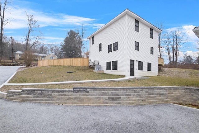 view of side of home with a yard and fence