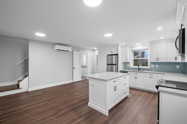 kitchen featuring a wall mounted air conditioner, a sink, backsplash, dark wood-style floors, and appliances with stainless steel finishes