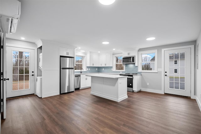 kitchen with appliances with stainless steel finishes, white cabinets, dark wood finished floors, and light countertops