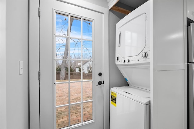 clothes washing area featuring laundry area and stacked washer and clothes dryer