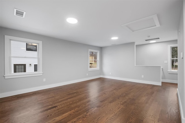 spare room with visible vents, baseboards, attic access, recessed lighting, and dark wood-type flooring