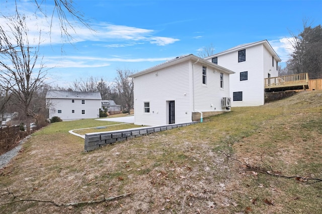 rear view of property featuring ac unit, a lawn, and a deck