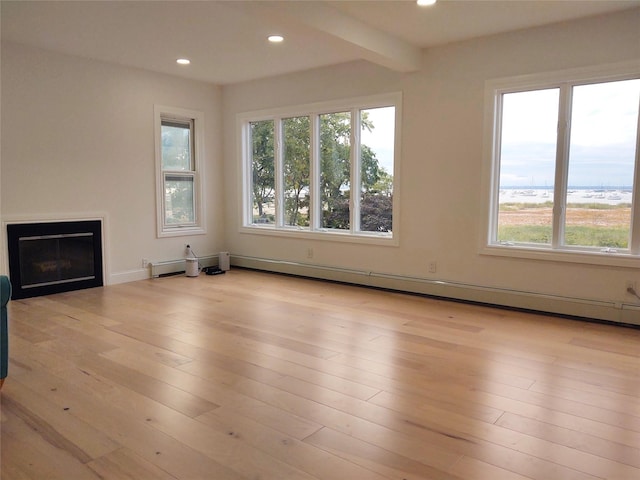 unfurnished living room featuring a glass covered fireplace, recessed lighting, wood finished floors, and a baseboard radiator