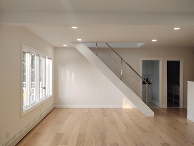 empty room with baseboards, stairs, baseboard heating, recessed lighting, and light wood-style flooring