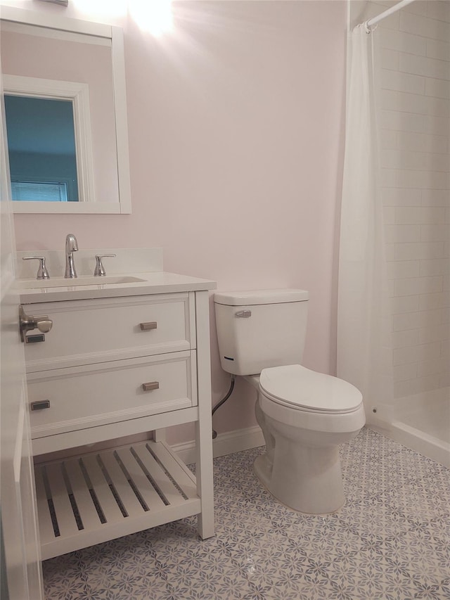 full bath with toilet, a stall shower, tile patterned flooring, baseboards, and vanity