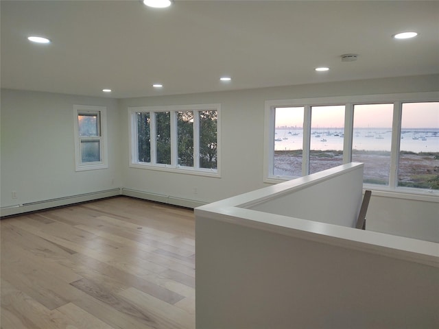 spare room featuring light wood-style flooring, plenty of natural light, and recessed lighting