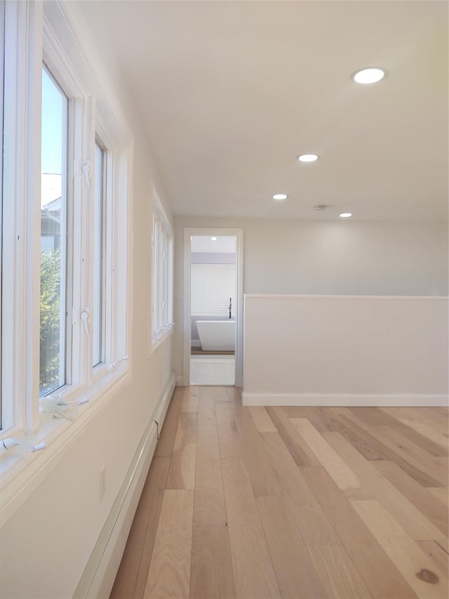 unfurnished room with light wood finished floors, recessed lighting, and baseboards