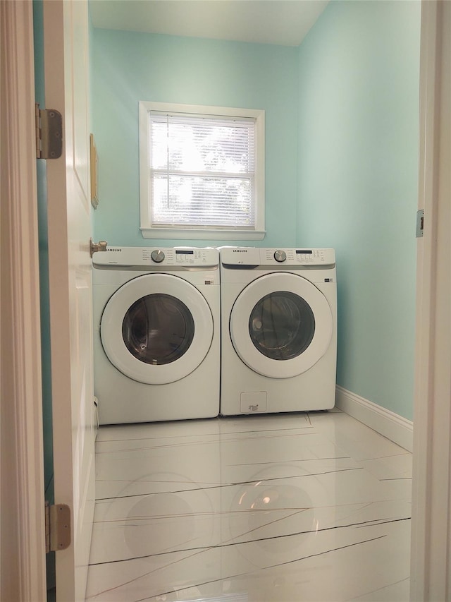 laundry room with baseboards, separate washer and dryer, and laundry area