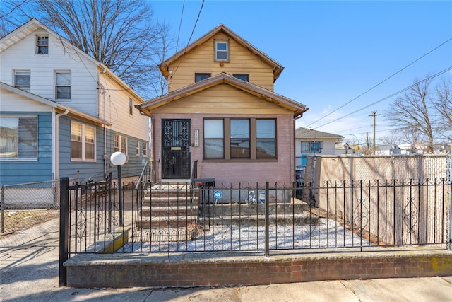 view of front of house featuring brick siding and a fenced front yard