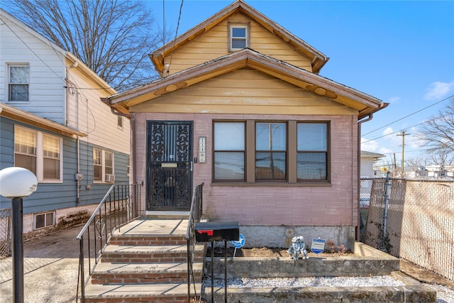 bungalow with crawl space, brick siding, and fence