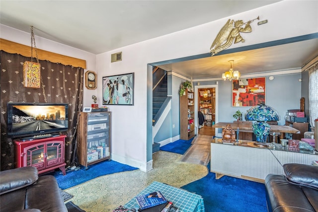 living area with stairway, baseboards, visible vents, and a chandelier