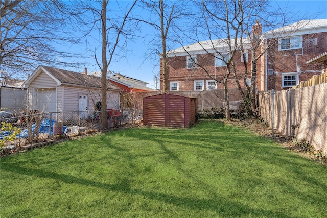 view of yard with a fenced backyard, a garage, and an outdoor structure