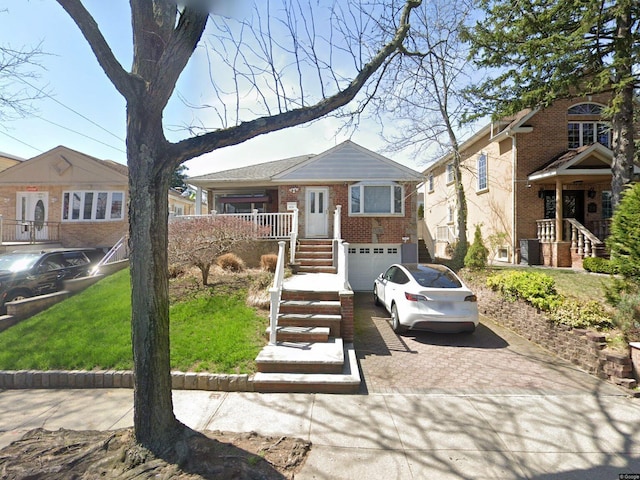 view of front of house featuring stairway, decorative driveway, brick siding, and a garage