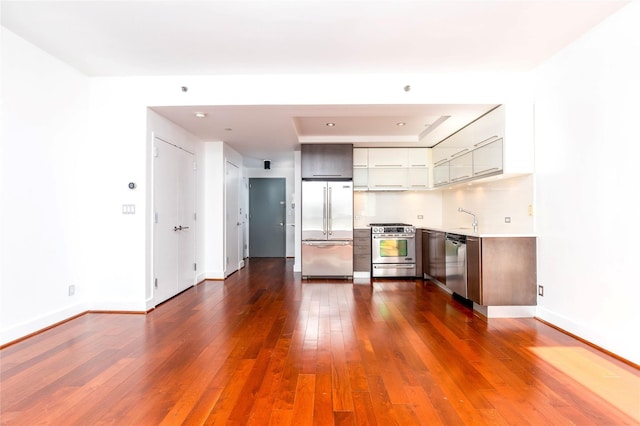 interior space with a sink, baseboards, and dark wood-style flooring